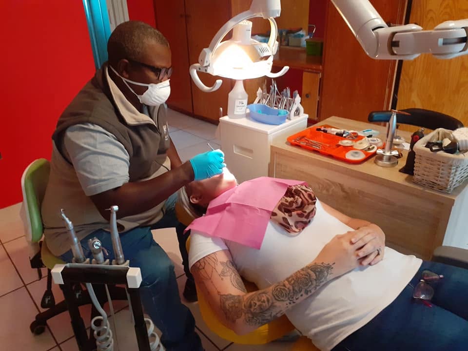 Dr Kutumela fitting orthodontic braces for a patient in the treatment chair