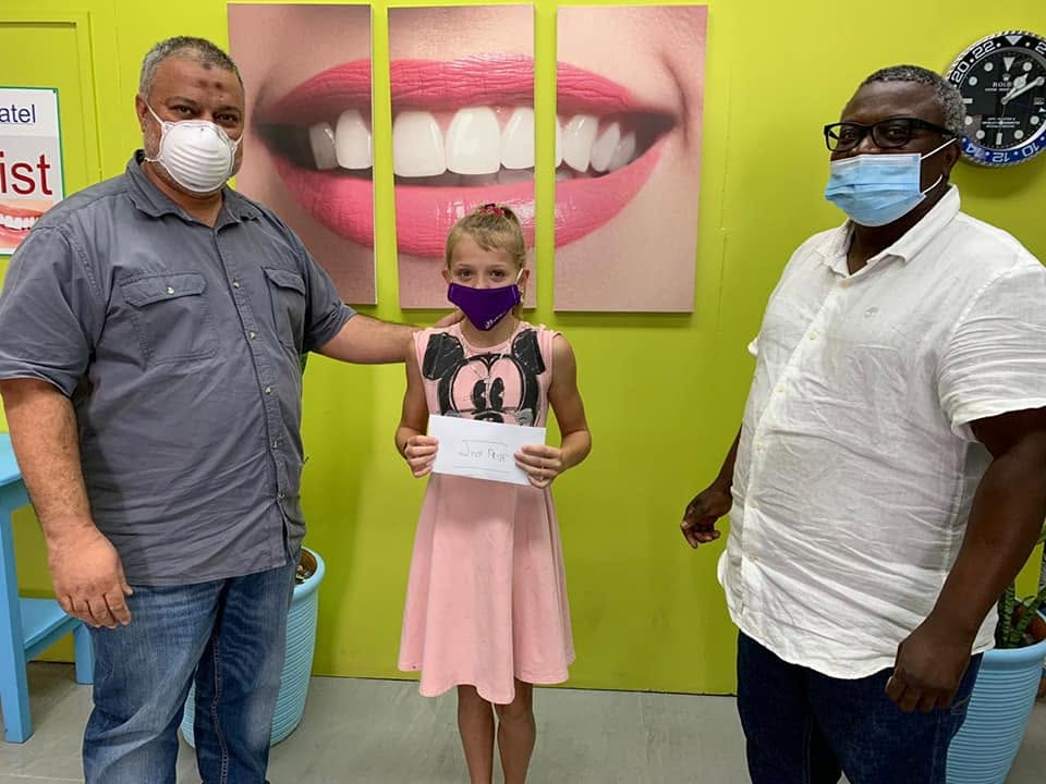 Dr Kutumela with a young patient celebrating a community dental health award